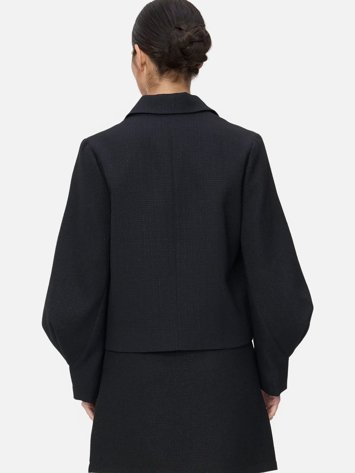 this black coat embraces your curves, blending lapel and V-neck elements with the charm of lantern sleeves.