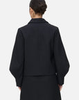 this black coat embraces your curves, blending lapel and V-neck elements with the charm of lantern sleeves.