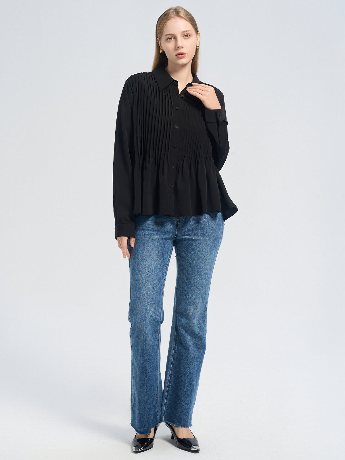 Stylish black pleated shirt for women, designed with a loose fit and flowy peplum detail