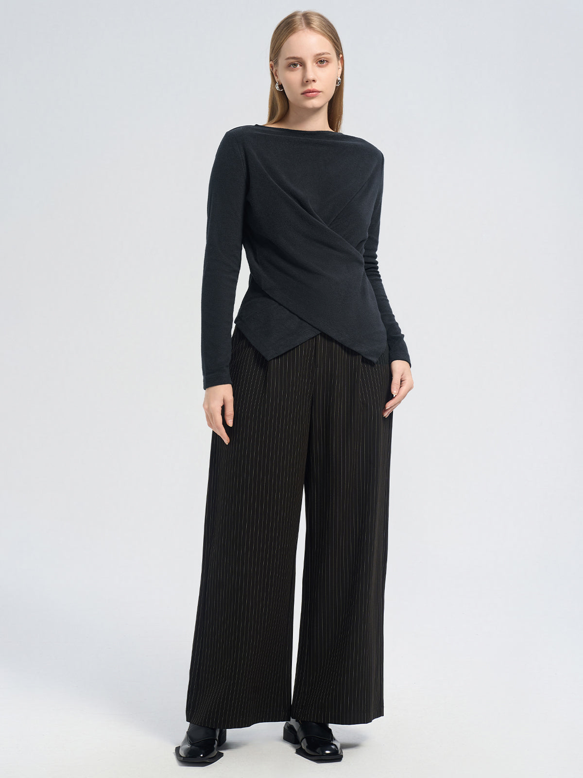 Asymmetric black long-sleeve top with a crossover pleated front