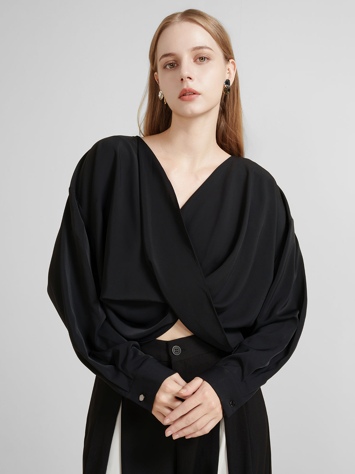 Women&#39;s black draped crossover blouse with long sleeves and a deep V-neck