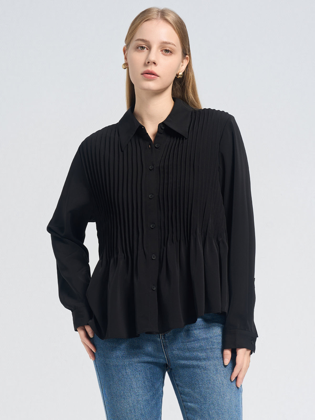 Chic black pleated shirt with a structured front, classic collar, and flared hem, perfect for work or casual styling