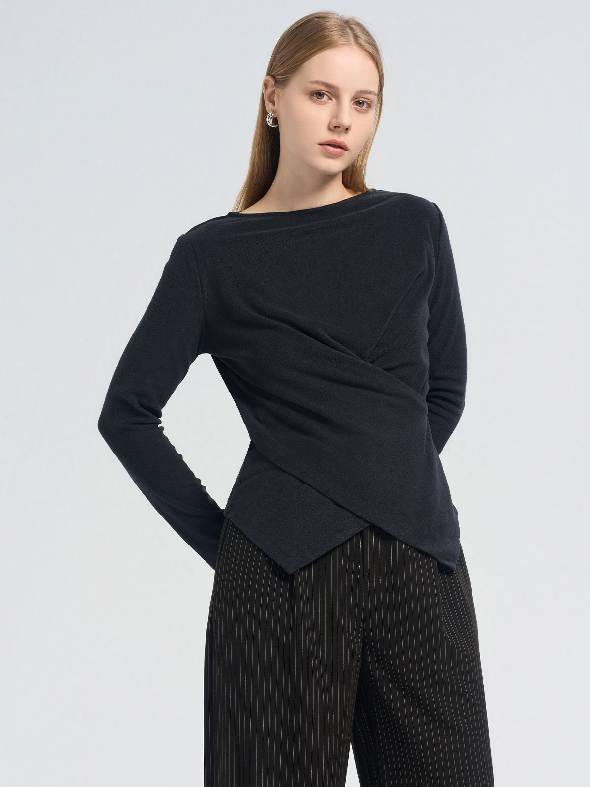 Asymmetric black long-sleeve top with a crossover pleated front