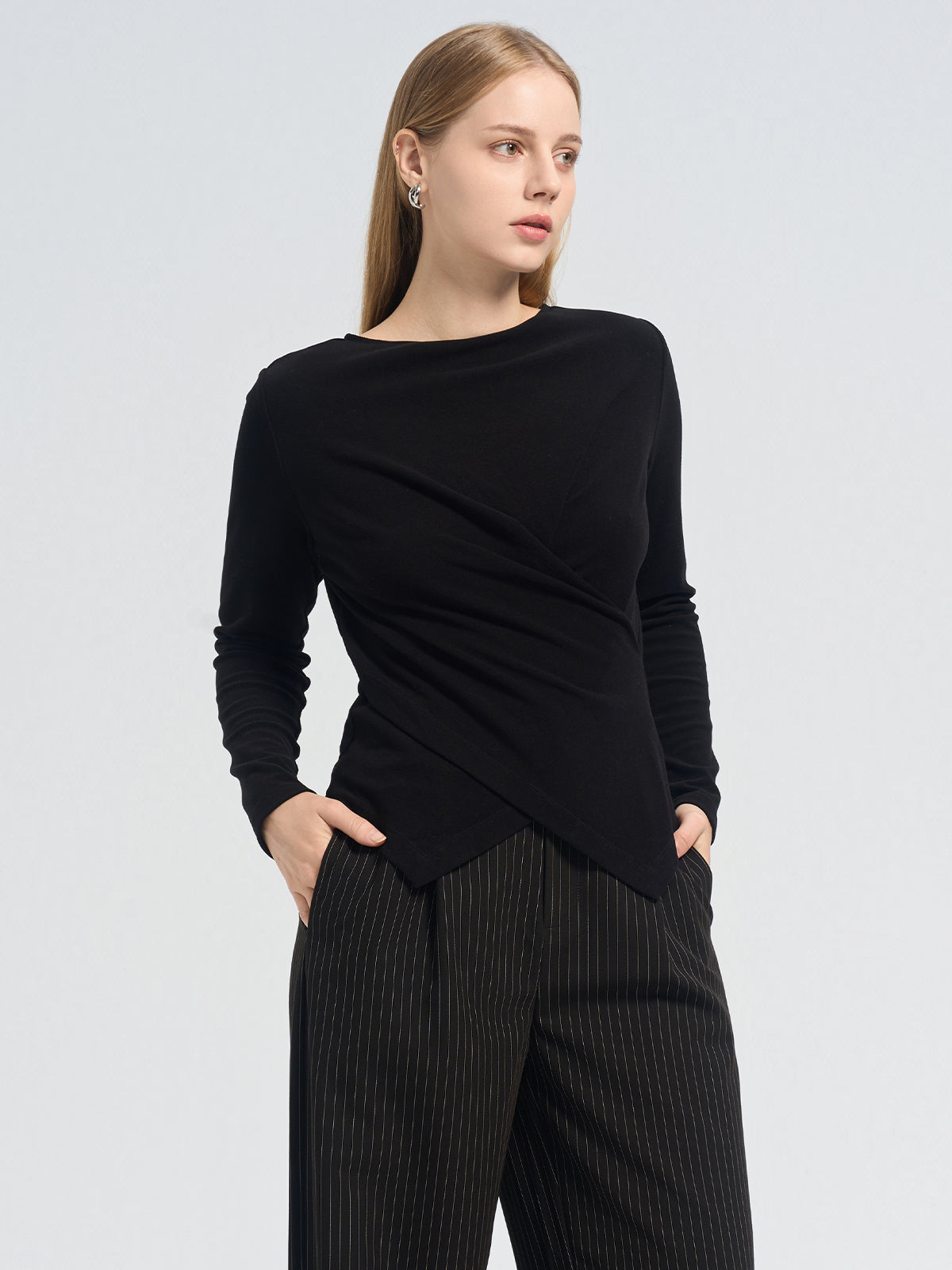 Asymmetric black long-sleeve top with a crossover pleated front