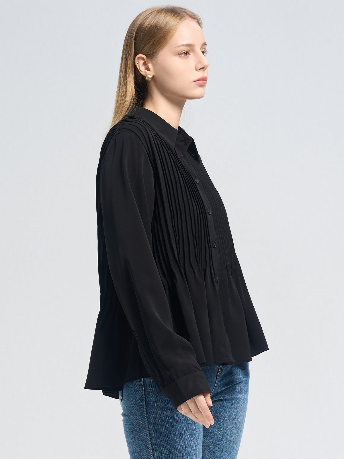 Elegant long-sleeve black blouse with vertical pleats and a relaxed silhouette, a versatile choice for modern wardrobes