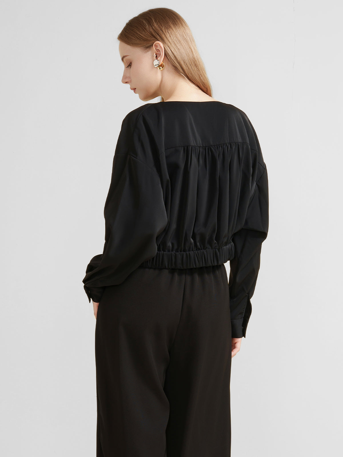 Women&#39;s black draped crossover blouse with long sleeves and a deep V-neck