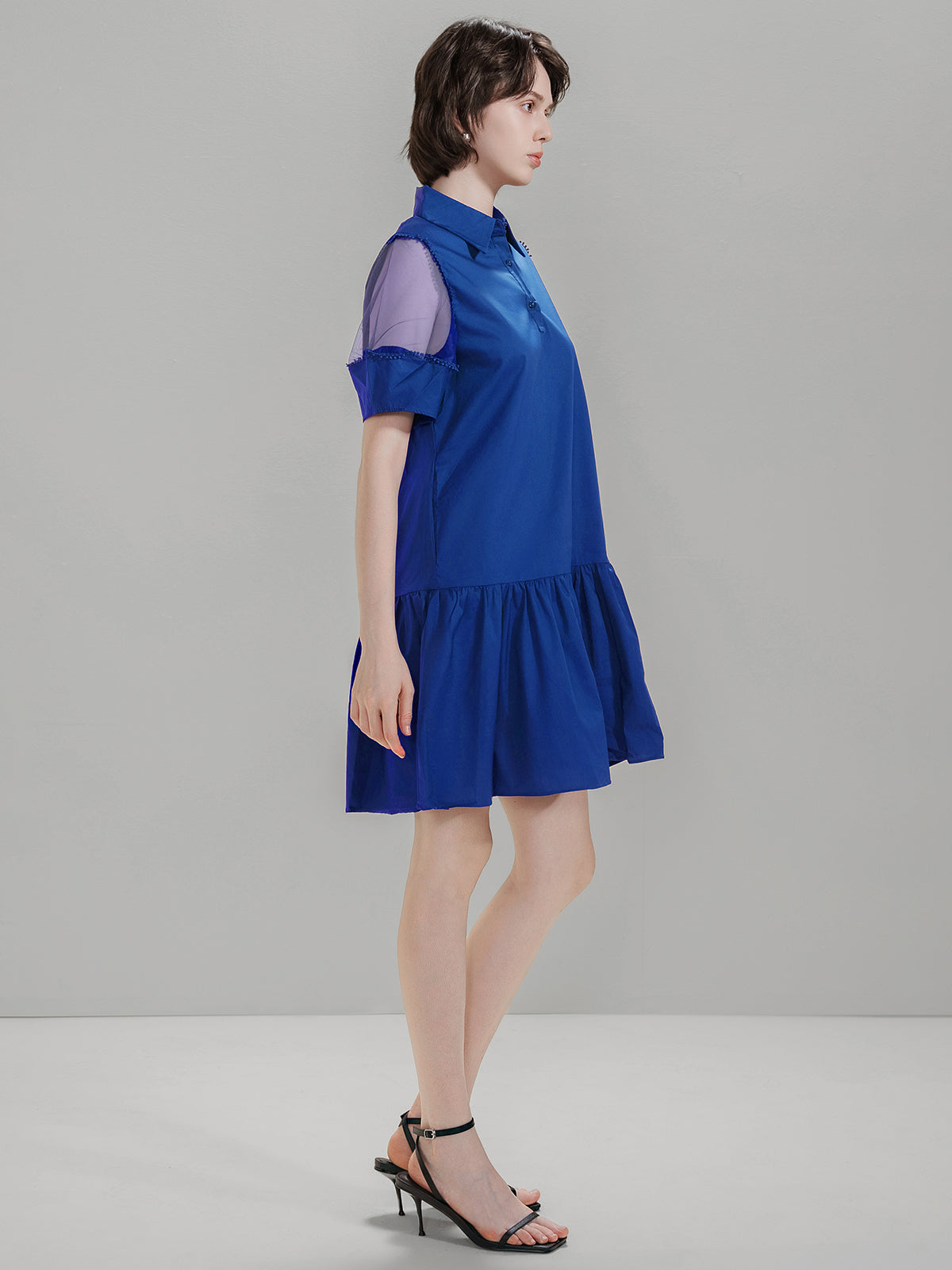 Side view of S·DEER blue dress with a loose fit, mesh sleeves, and ruffled hem