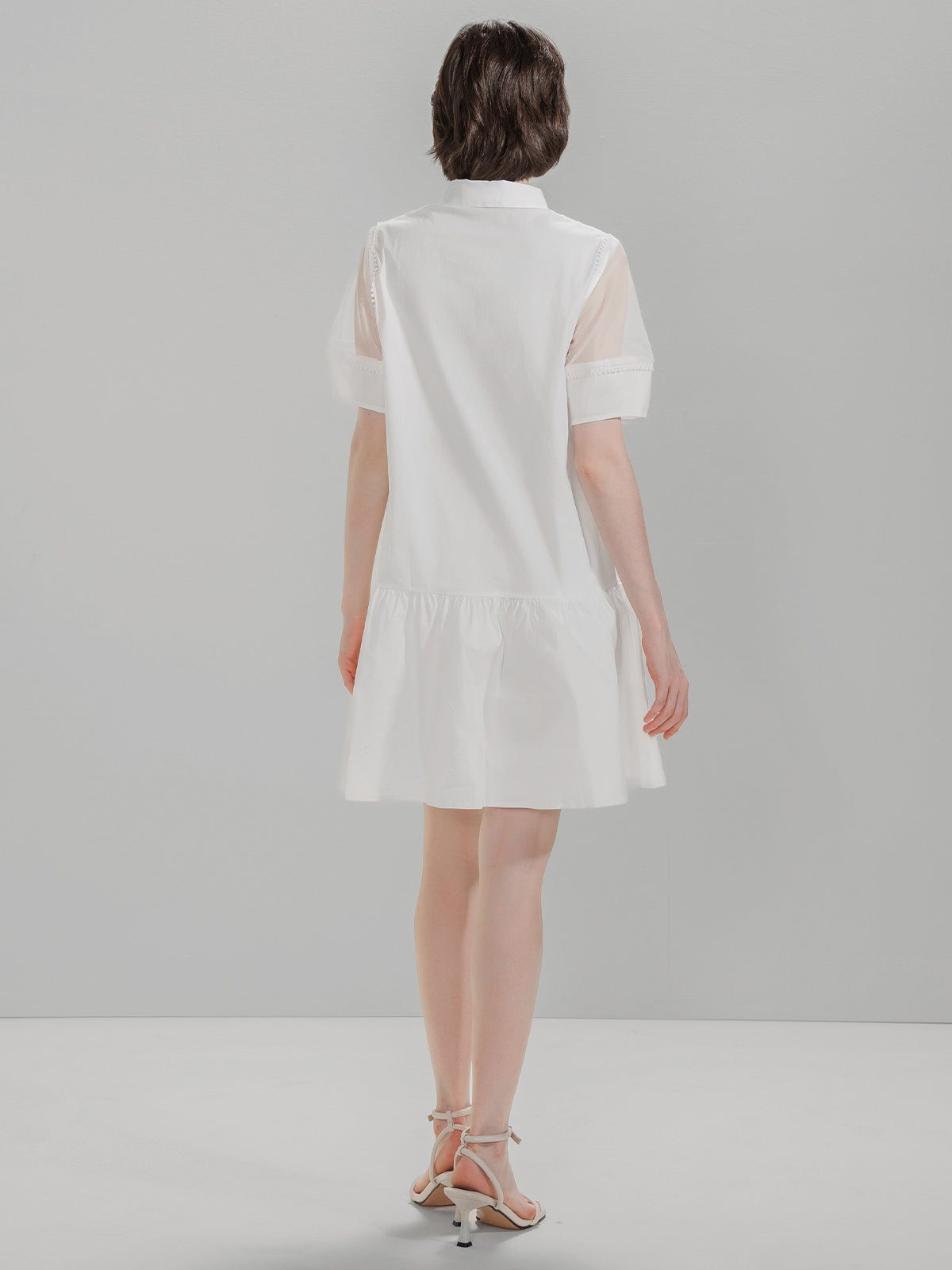 Back view of S·DEER white shirt dress with mesh details on the shoulders and flared skirt