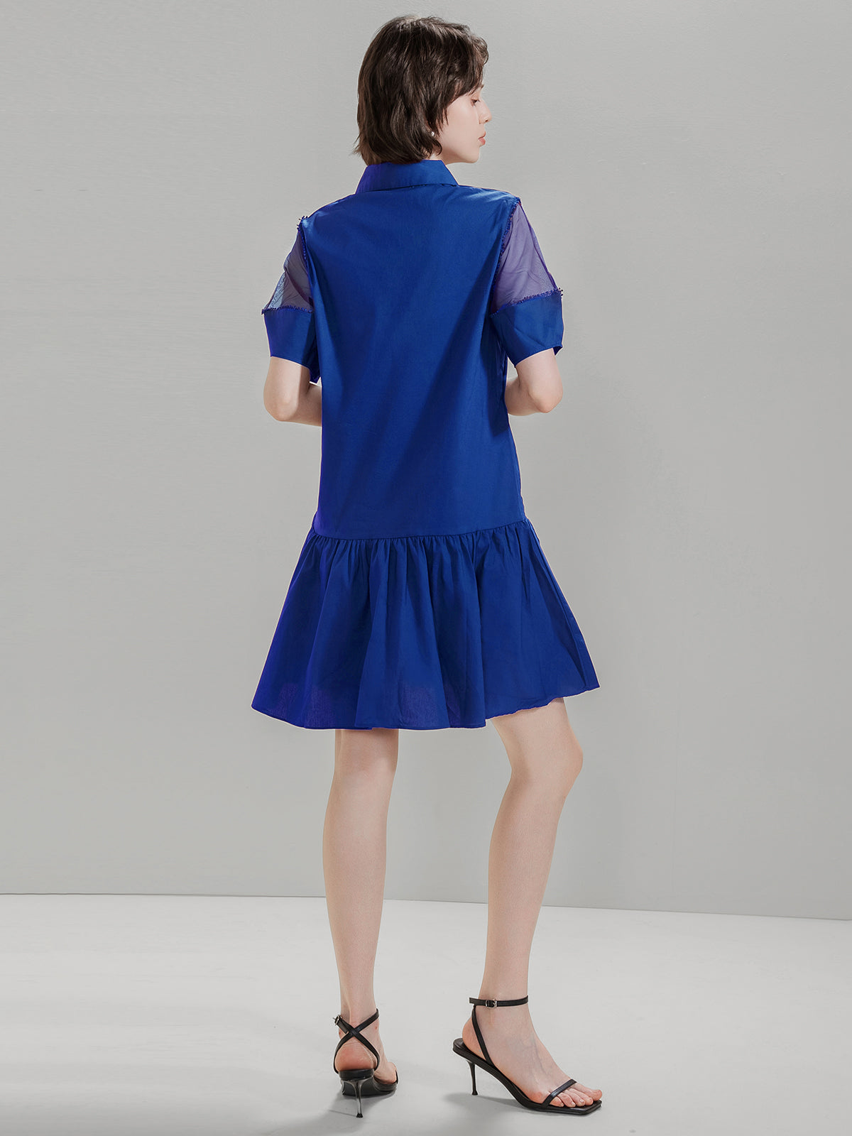 Back view of S·DEER blue shirt dress with mesh details on the shoulders and flared skirt