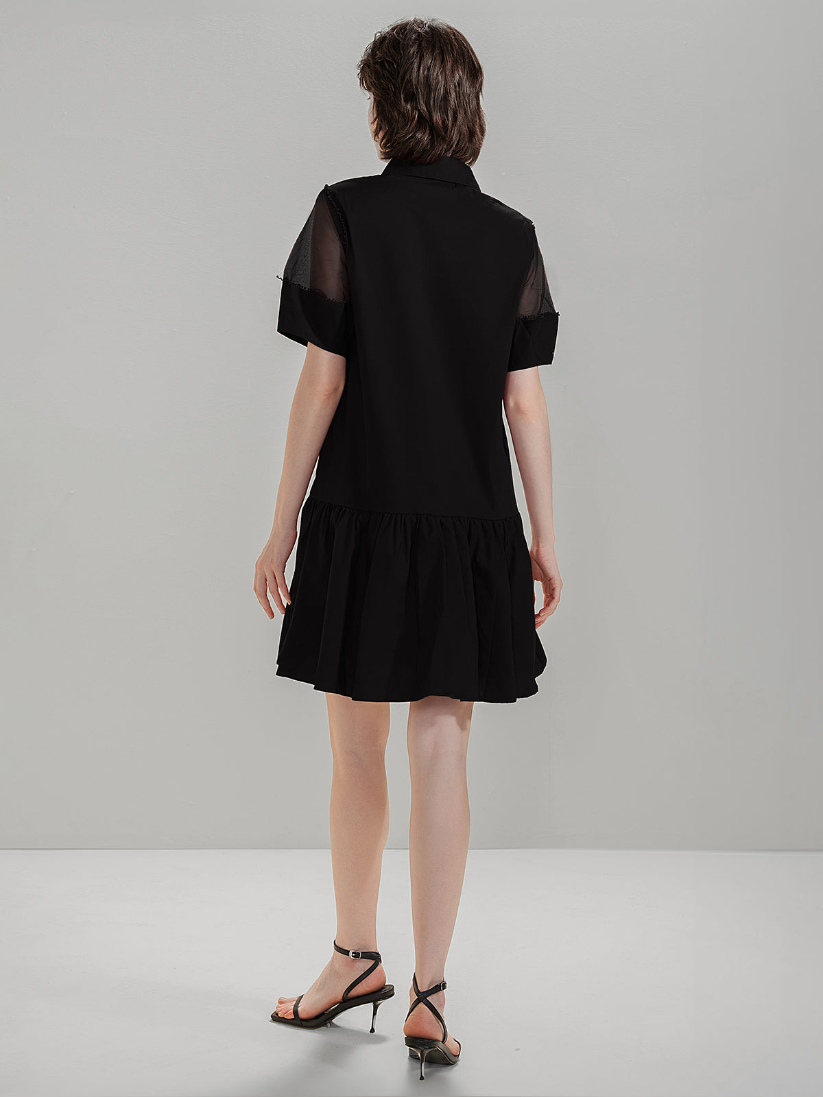 Back view of S·DEER black shirt dress with mesh details on the shoulders and flared skirt