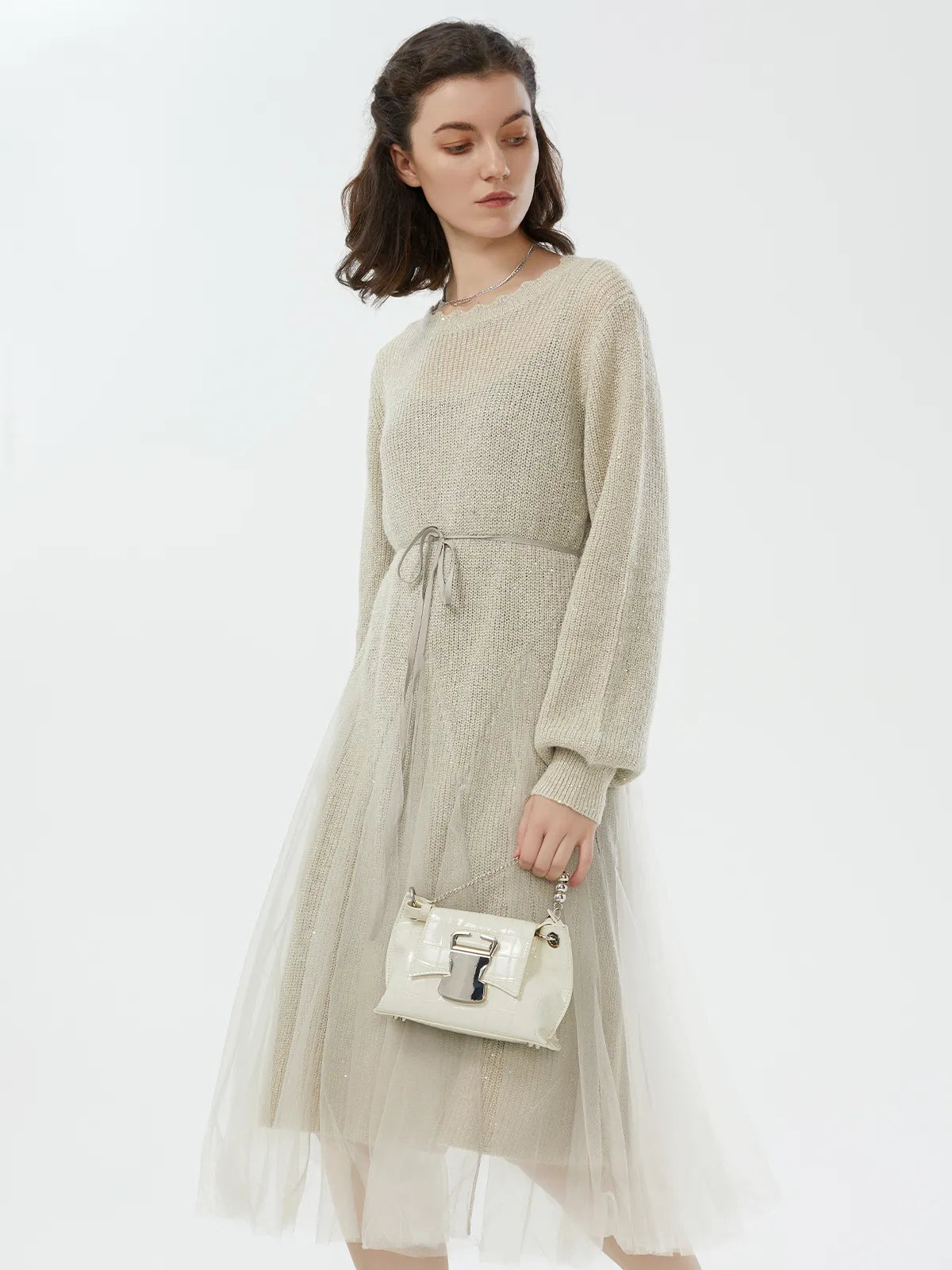 Side view of beige sweater dress with an elegant silhouette and layered tulle details