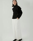 Knit sweater style with an asymmetrical ruffled edge design