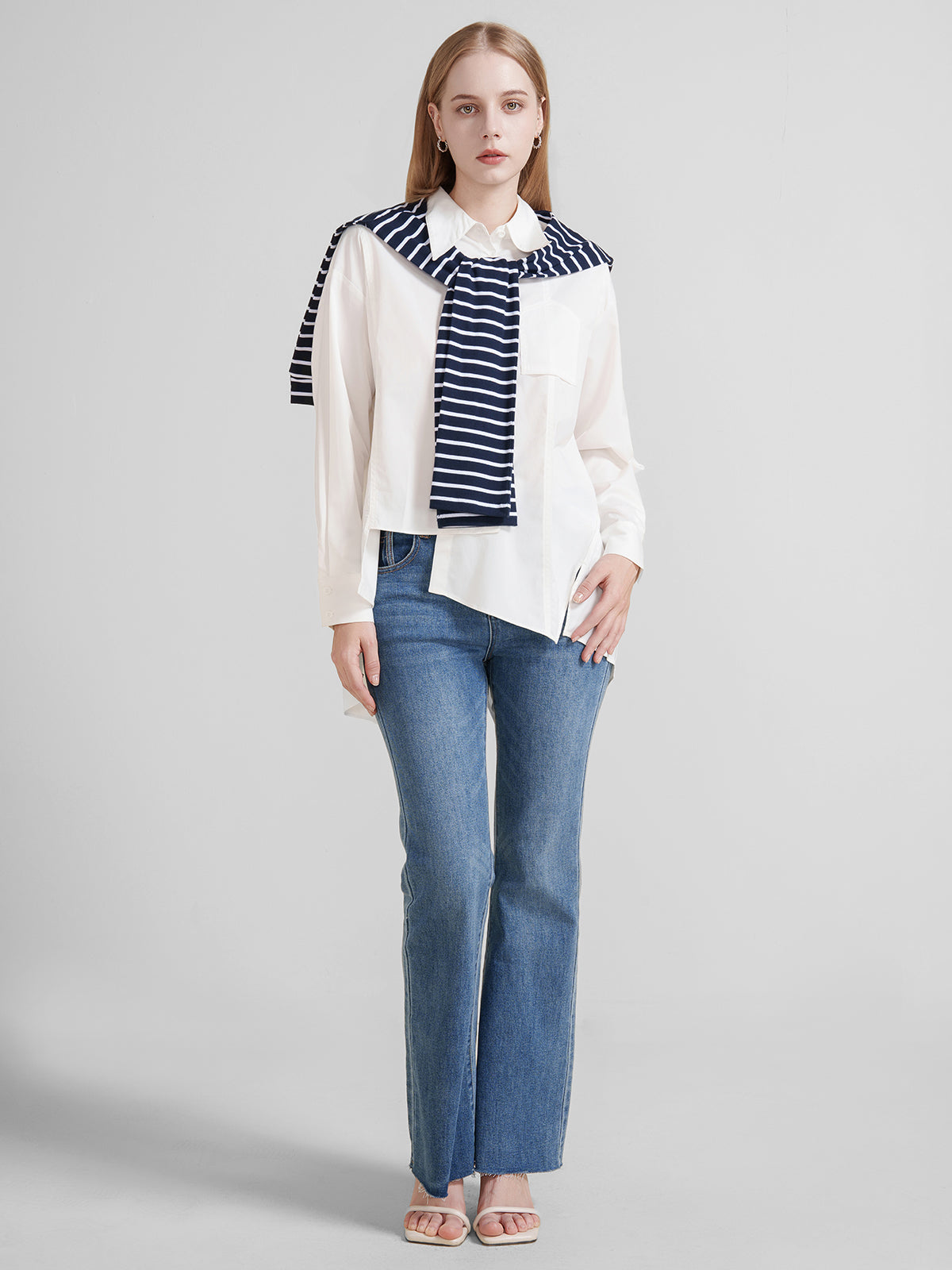 Women&#39;s oversized white button-up shirt with asymmetrical hem and long sleeves