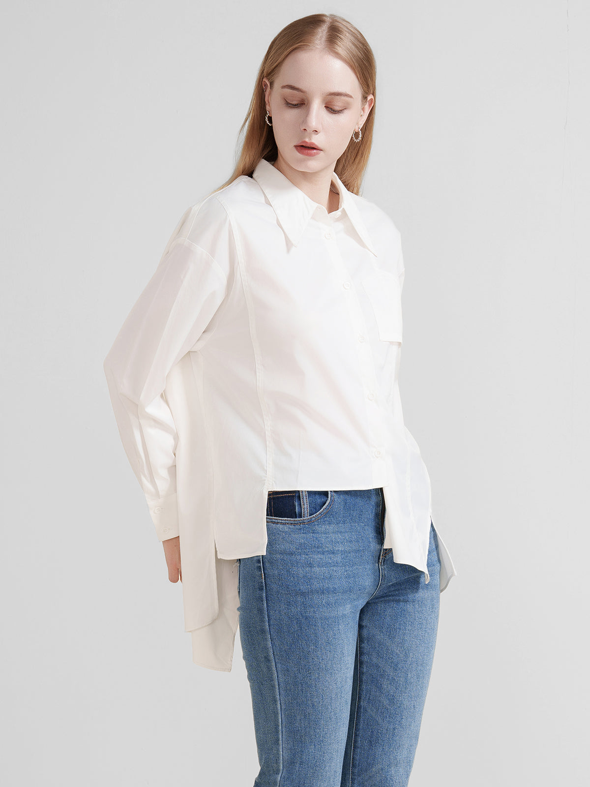 Stylish loose-fit white shirt with a unique asymmetrical cut and classic collar