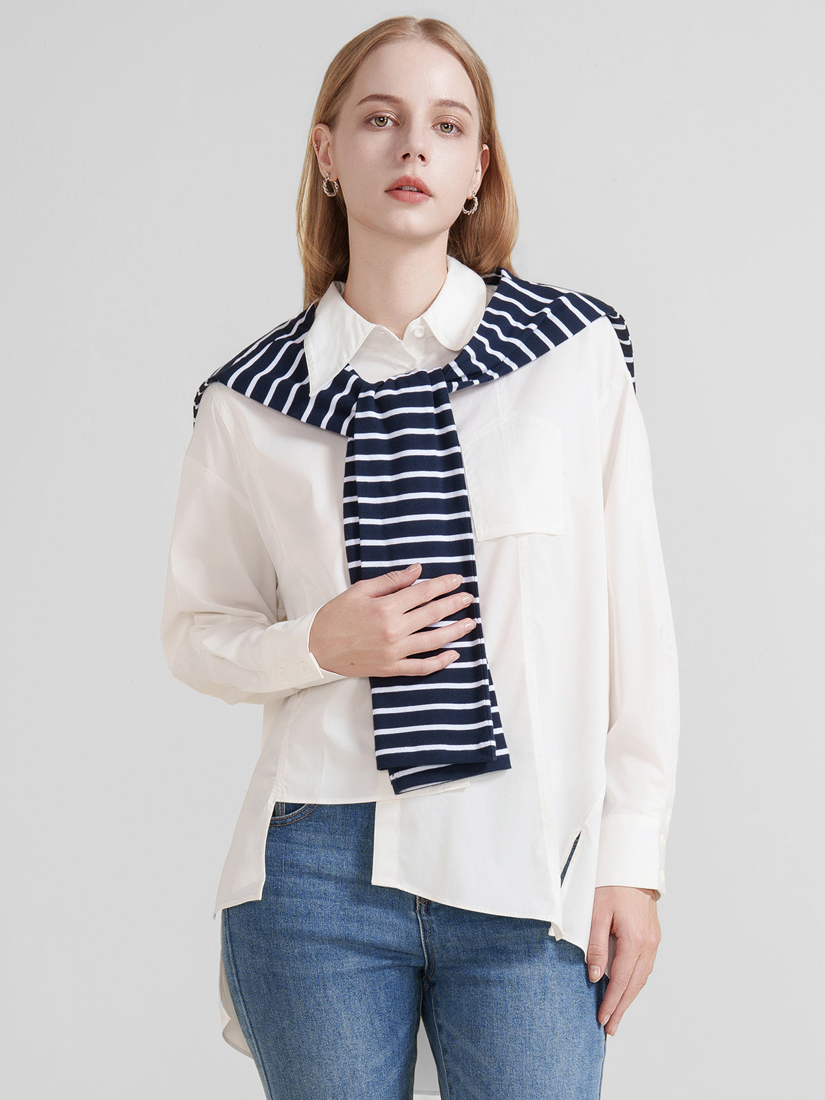 Women&#39;s oversized white button-up shirt with asymmetrical hem and long sleeves