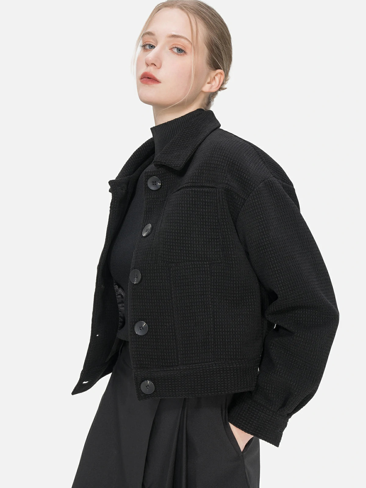 Make a style statement with this elegant black short jacket, showcasing a collared design, a unique waffle-grid pattern, and a snug fit.
