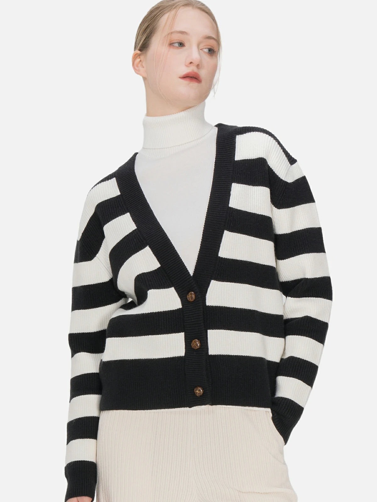 Achieve a contemporary look with this black and white striped V-neck cardigan, boasting a loose fit and elegant button details, seamlessly blending sophistication and relaxed style.