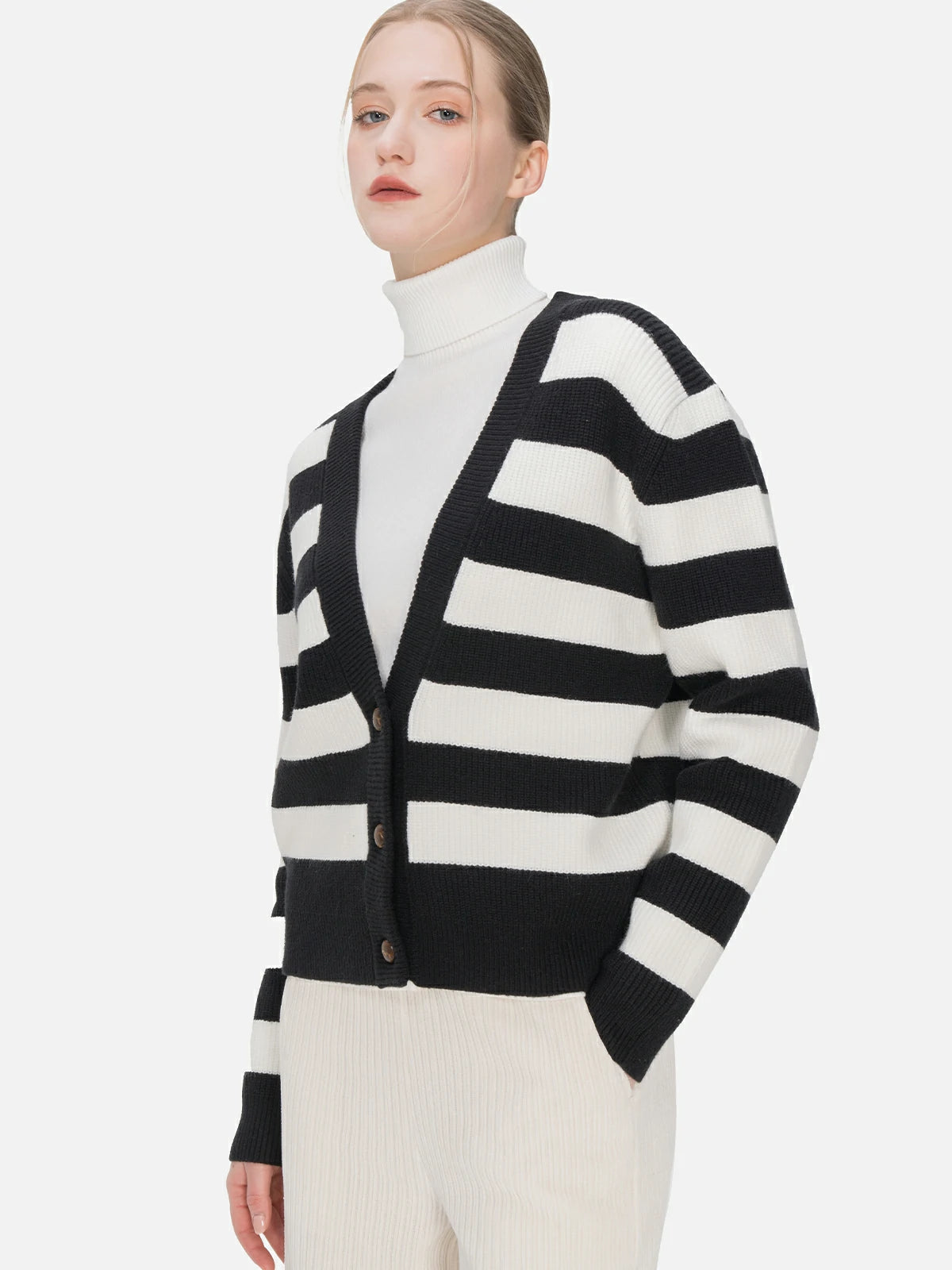 Versatile styling options await with this V-neck cardigan in a loose fit, featuring black and white stripes, button details, and a design that effortlessly combines sophistication and ease.
