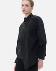 Versatile black shirt featuring a sophisticated chest panel, adding a touch of fashion-forward detailing for a polished look.