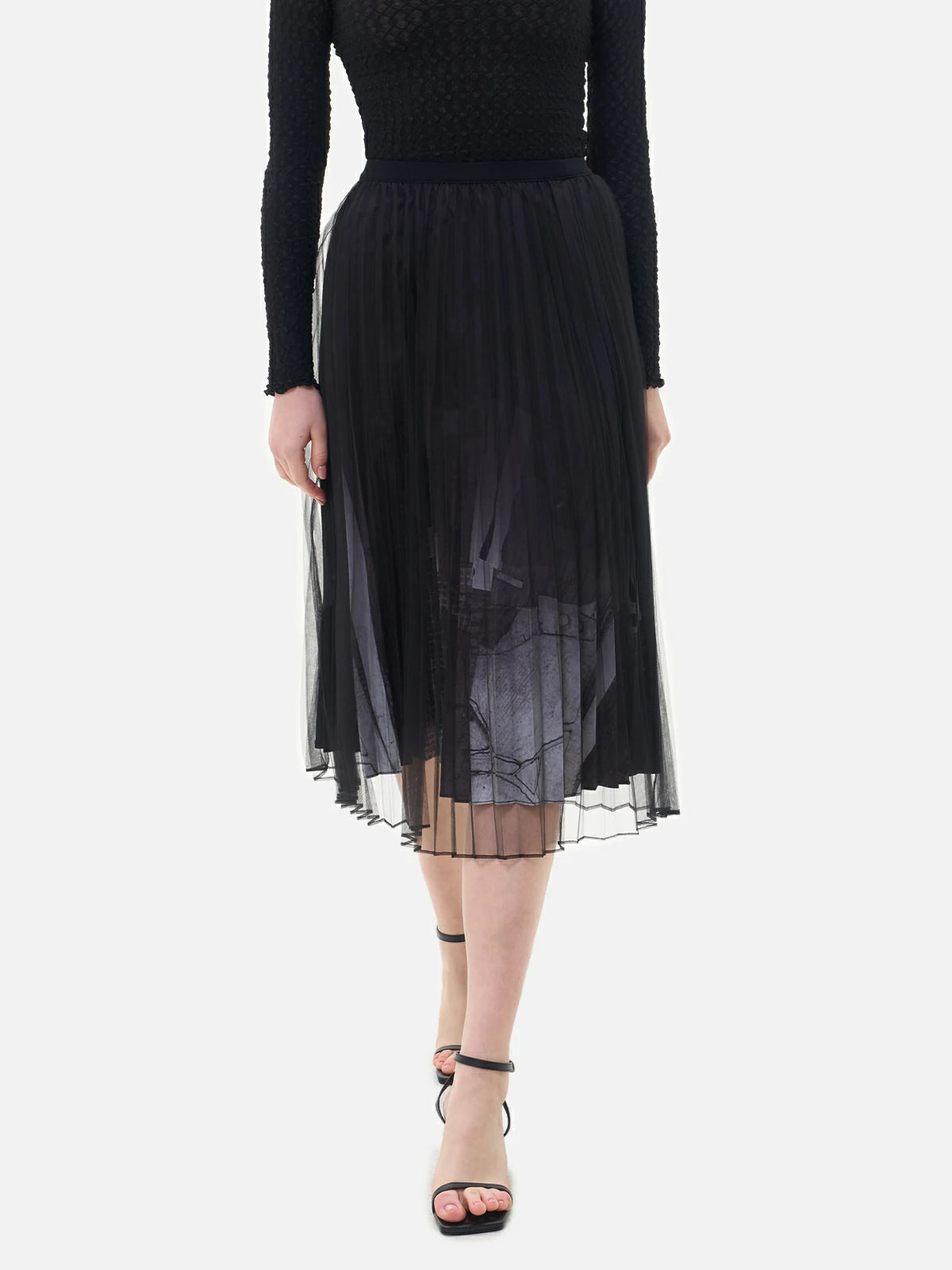 This double-layer skirt features a pleated inner lining, a black-and-white printed pattern, and a structured silhouette.