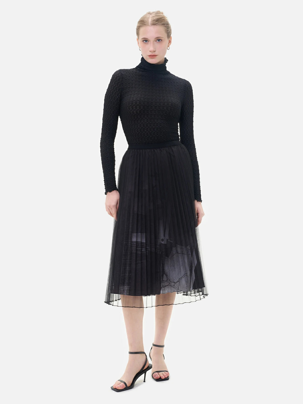 This double-layered skirt, boasts a pleated inner lining, a stylish black and white printed pattern, and a structured silhouette.