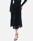 A stylish black semi-transparent midi skirt with V-shaped pleats, showcasing the unique and elegant charm of women.