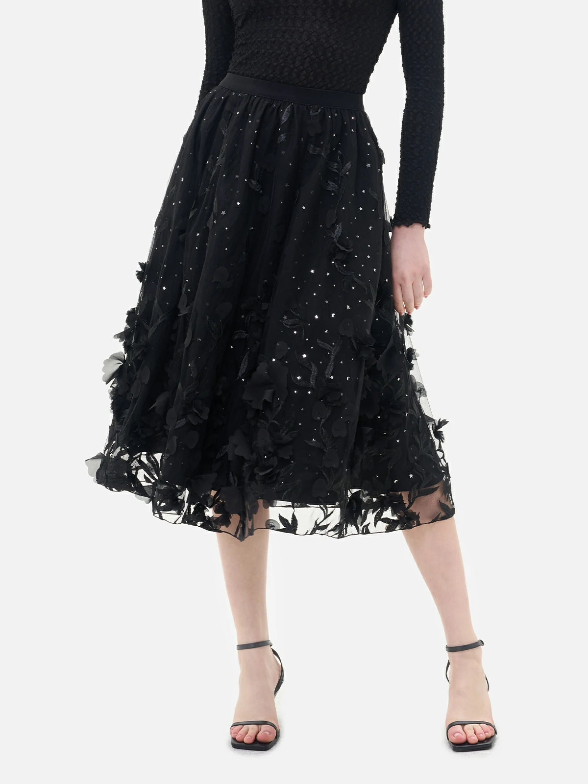 Stylish black double-layered skirt with inner lining adorned with star-shaped sequins, perfect for a glamorous look.