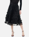 Stylish black double-layered skirt with inner lining adorned with star-shaped sequins, perfect for a glamorous look.