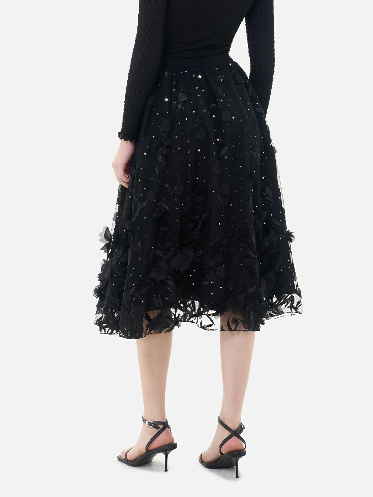 Exquisite craftsmanship is displayed in the embroidered details and appliqué flowers of this fashionable black double-layered skirt.