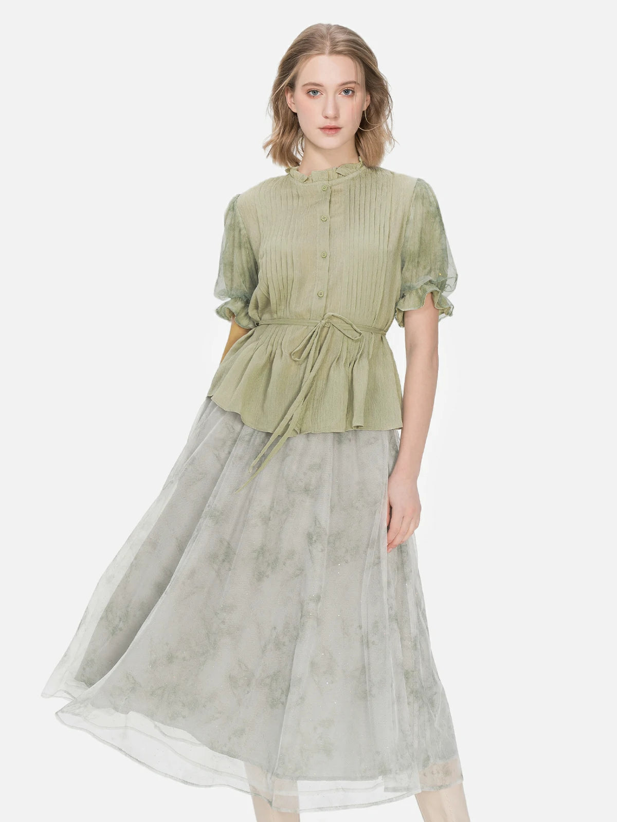 Stylish short-sleeved blouse in green with a waist tie, accordion pleat detailing, and mesh bubble sleeves for a fashionable appearance.