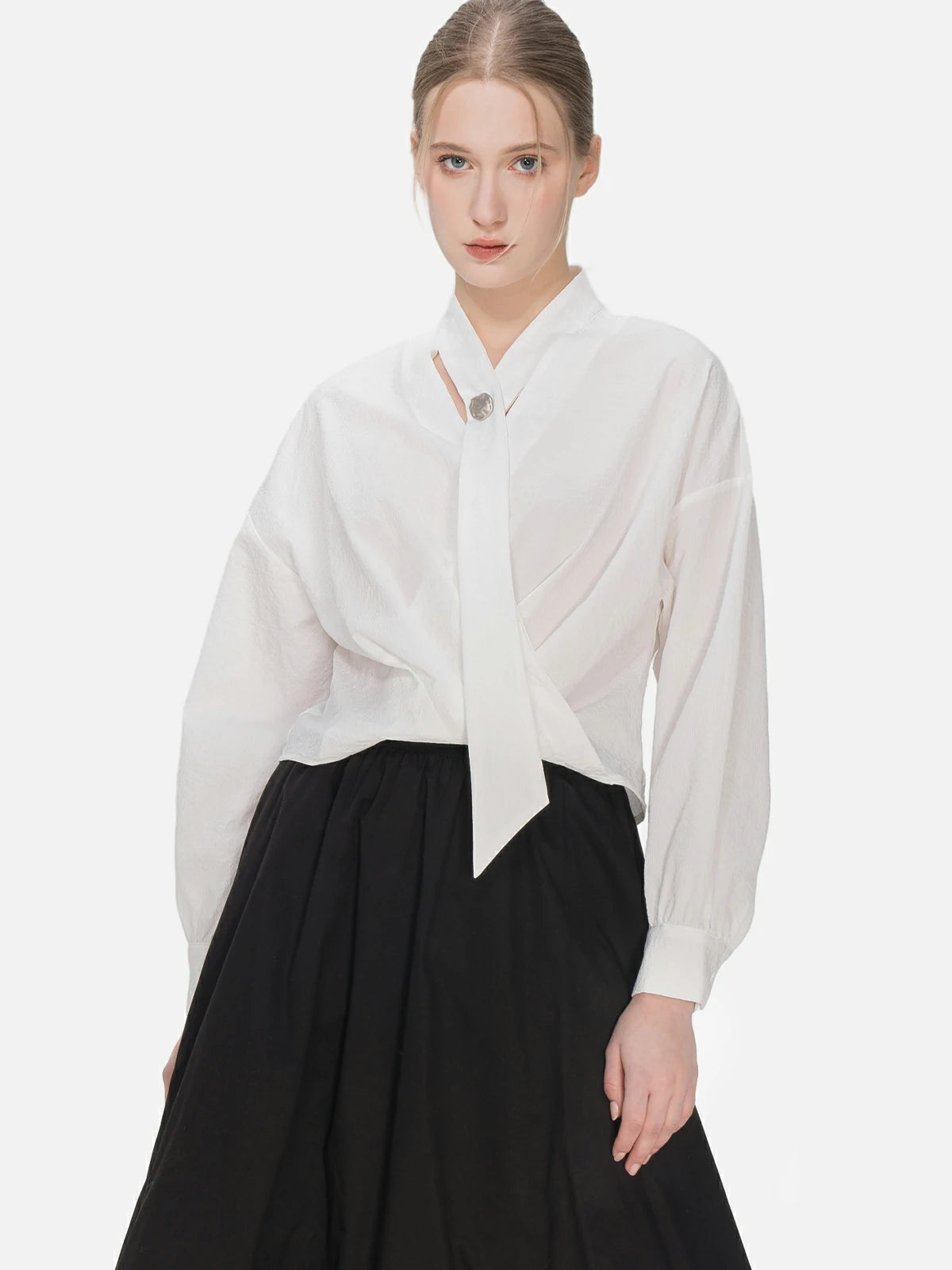 Stylish V-neck blouse with cascading ribbons, featuring a modern and elegant cross-pleat design for a uniquely charming appearance.
