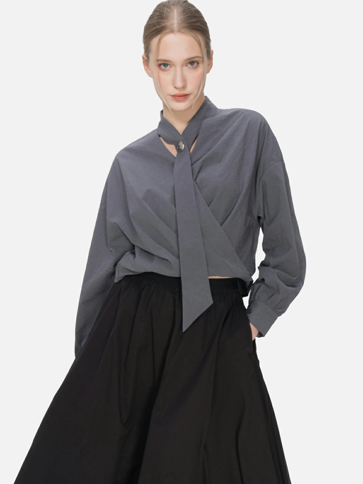 V-neck blouse with cascading ribbons and a cross-folded hem, embodying a modern and elegant fashion statement with unique charm.