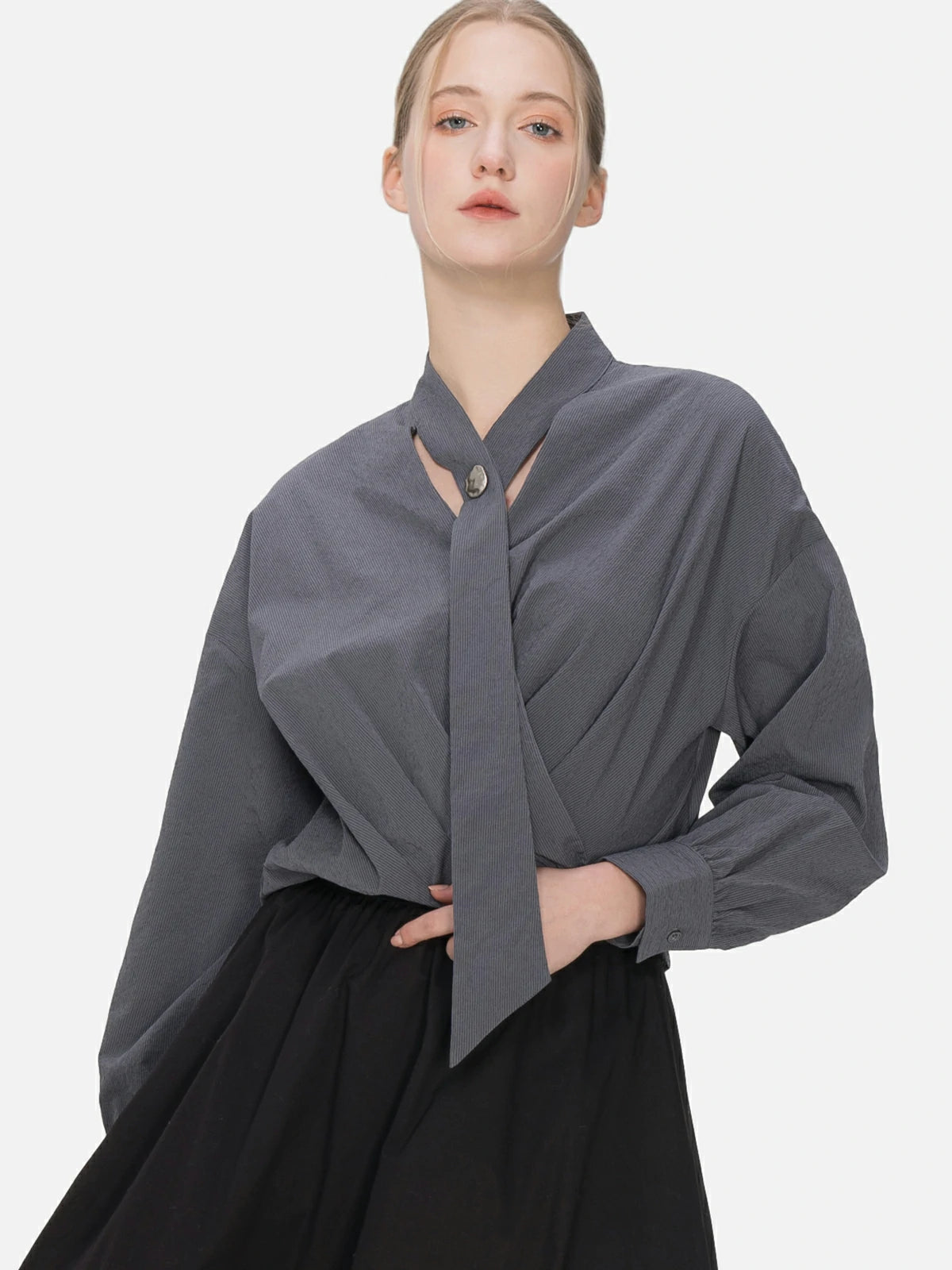 Modern elegance: V-neck blouse showcasing cascading ribbons and a cross-pleat design, creating a uniquely charming and fashionable silhouette.
