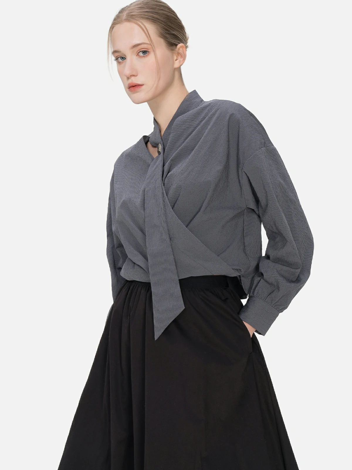 Unique charm meets contemporary style in this V-neck blouse with cascading ribbons and a cross-folded hem, perfect for a fashion-forward look.