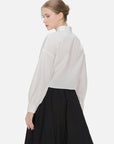 Elegant blouse with V-neck and cascading ribbons, showcasing a cross-pleat design for a modern and sophisticated fashion look.