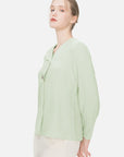 Immerse yourself in the refreshing allure of this V-neck chiffon blouse, characterized by pleated cuffs and stylish green color.
