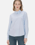 Stylish ladies' collared shirt with a unique diagonal button design and classic blue color, perfect for a fashionable and elegant look on various occasions.