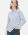 Tailored fit ladies' shirt featuring a diagonal button design and timeless blue color, offering a comfortable and refined option for both formal and casual settings.