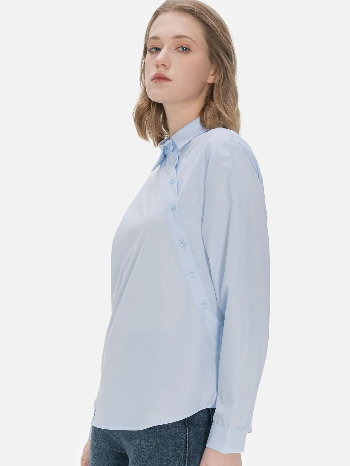 Versatile ladies&#39; shirt in classic blue, adorned with a unique diagonal button design, combining elegance and fashion for a chic and timeless ensemble.