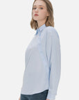 Versatile ladies' shirt in classic blue, adorned with a unique diagonal button design, combining elegance and fashion for a chic and timeless ensemble.