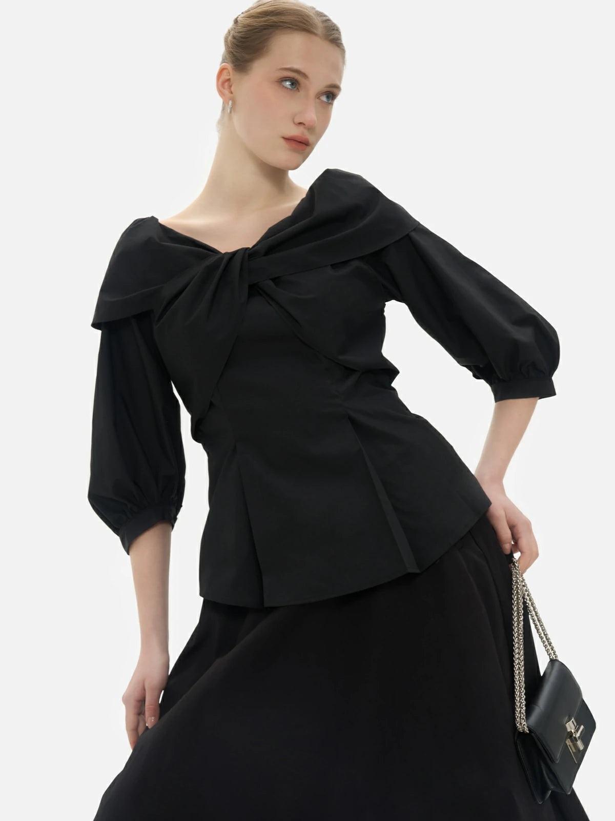 Transition effortlessly through seasons with this uniquely designed seven-quarter sleeve blouse, showcasing a layered pleat design and an oversized bow.
