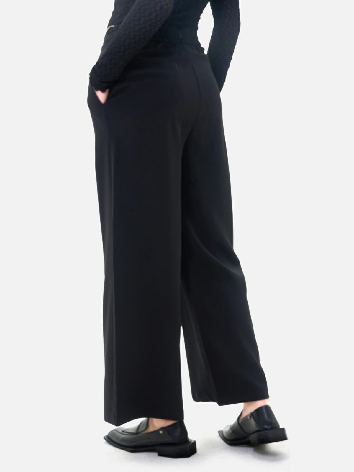 Uniquely designed black wide-leg pants with a waistband flip and color-blocking detail, adding a vibrant touch to the overall look