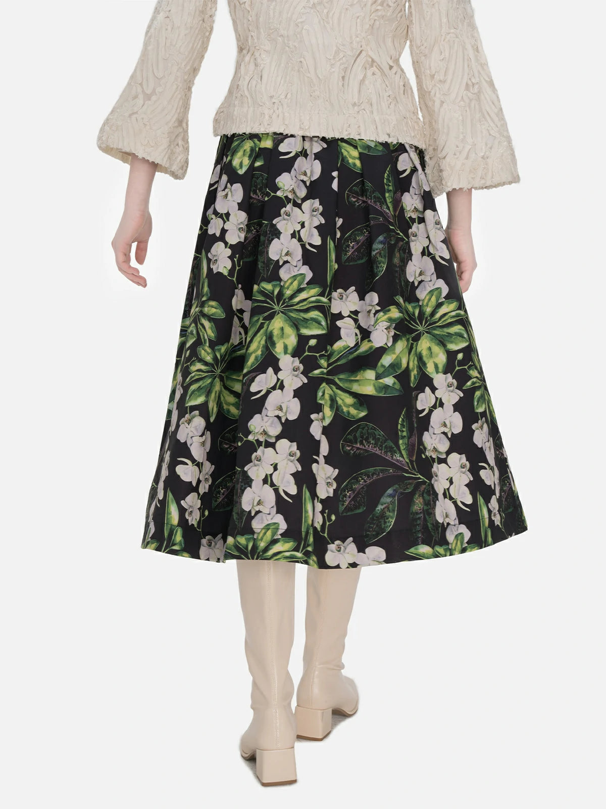 Elegant A-line midi skirt featuring a high-waisted design, vibrant color-blocked floral pattern, and layered pleats, creating a tailored fit suitable for different body types.