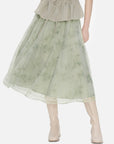 Fresh green A-line midi skirt with an elastic waistband, featuring sheer mesh fabric and subtle floral prints, for a uniquely feminine and comfortable style.