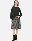 Stylish two-piece ensemble featuring a round-neck pullover sweater with an irregular hem design and a sleeveless dress adorned with a pleated floral print.