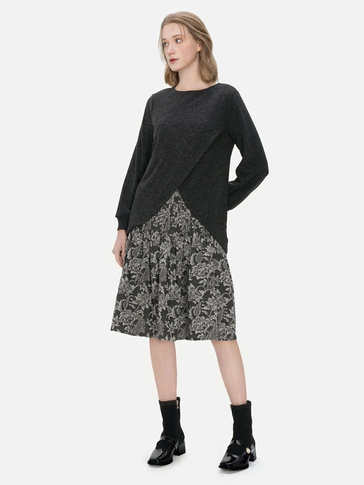 Achieve a confident and stylish look in this two-piece ensemble, consisting of a round-neck pullover sweater with an irregular hem and a sleeveless dress with a pleated floral print for a touch of elegance.