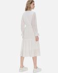 Versatile mid-length dress with white design, neckline tie, waist tie, and ruffle edges, combining fashion-forward elements.