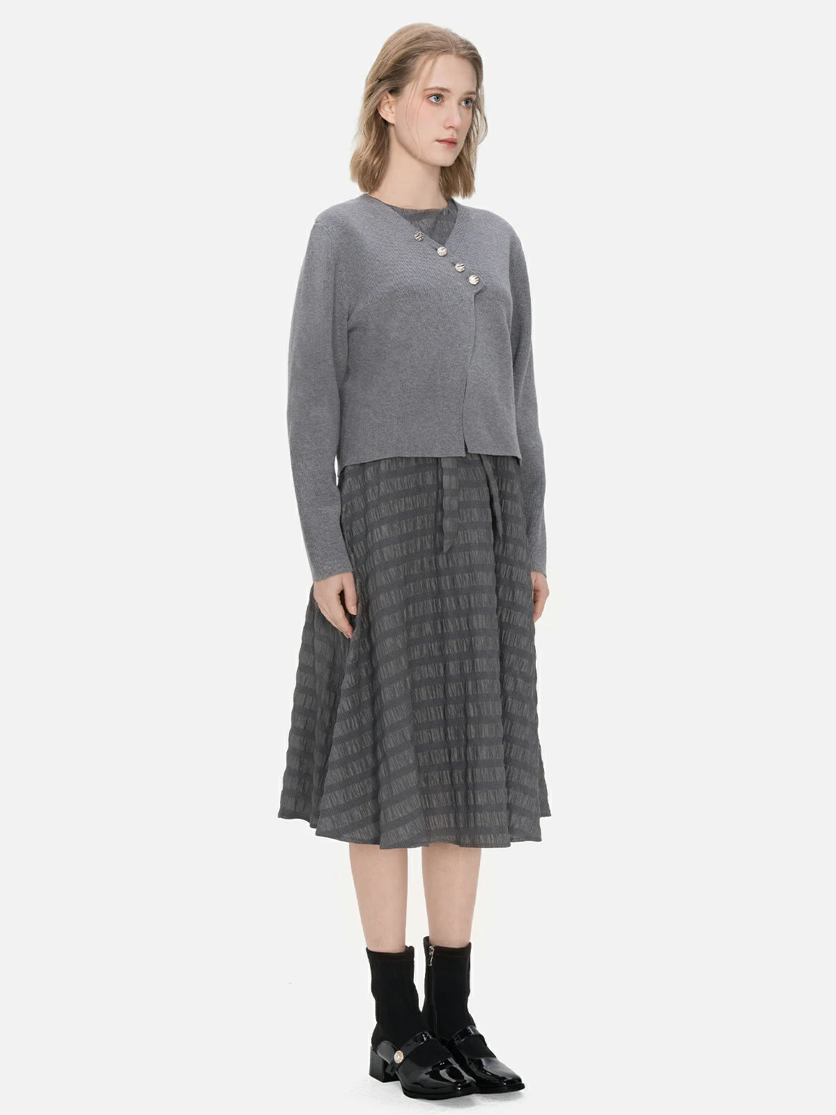 Embrace versatility and elegance with this ensemble, combining an irregular buttoned cardigan and a sleeveless A-line dress with a textured stripe design, making it a unique and fashionable choice for various occasions.