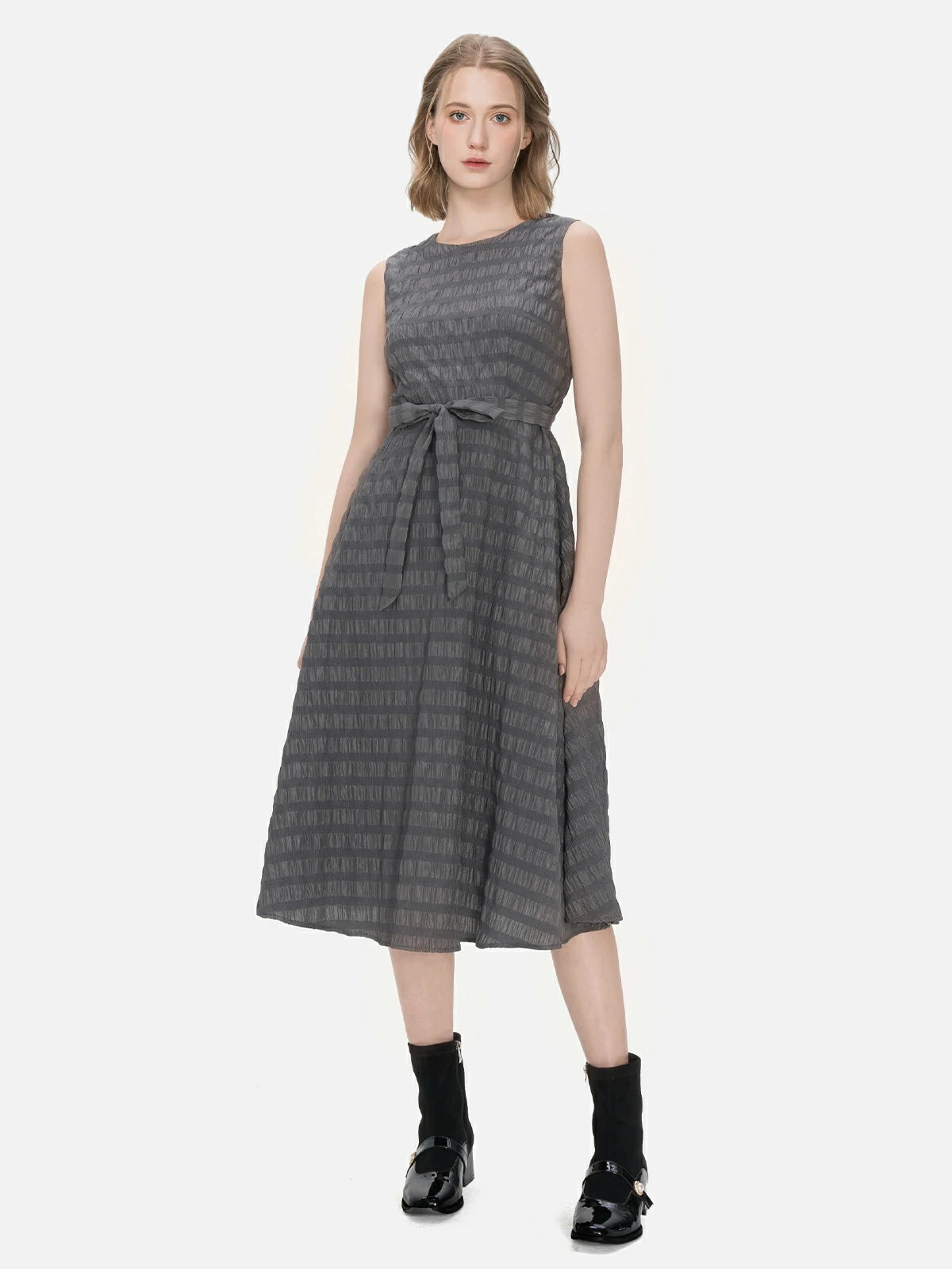 Step into the spotlight with this avant-garde-inspired two-piece set, showcasing an irregular buttoned cardigan paired with a sleeveless A-line dress featuring a stylish striped texture, offering both comfort and sophistication.