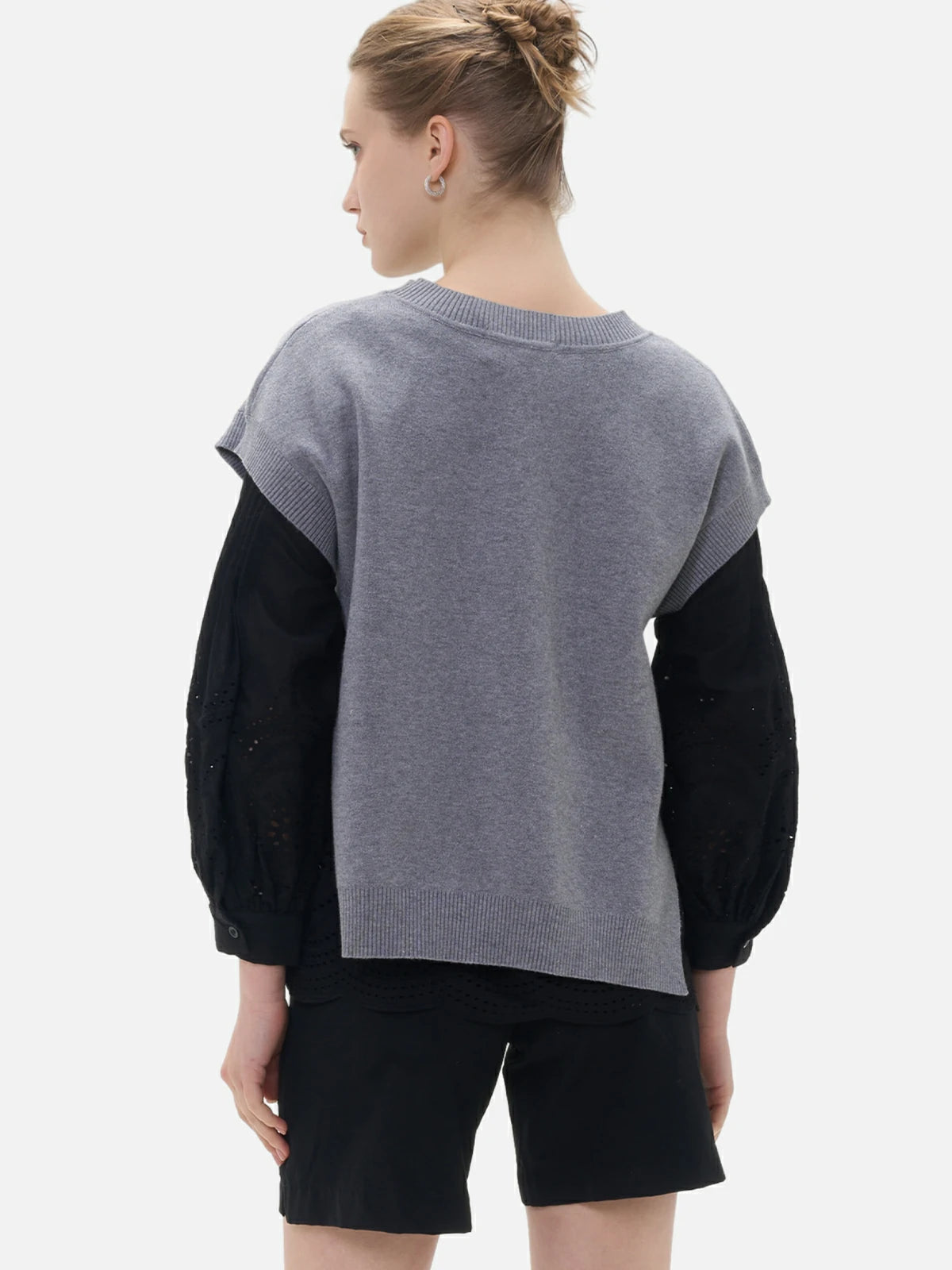 A casual yet stylish dropped-shoulder gray sweater complements the chic black shirt